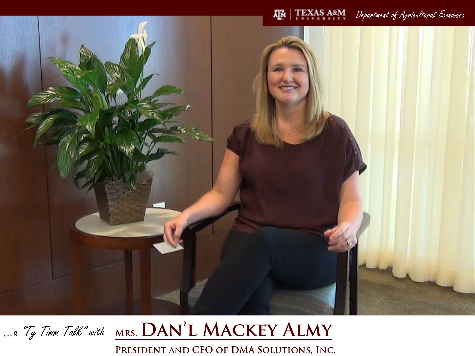 Dan'l sitting in chair in front of curtained window with a potted plant to her right. The words "A Ty Timm Talk with Mrs. Dan'l Mackey Almy, president and CEO of DMA Solutions Inc.