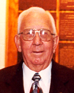 Jack Finney in a black suit against an orange background.