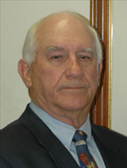 A portrait James Sartwelle, Jr. in a black suit against a white background.