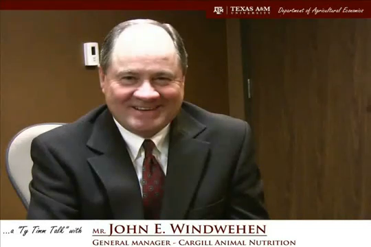 Thumbnail. The words "a Ty Tim talk wit Mr. John W. Windwehen - General Manager - Cargill Animal Nutrition" run along the bottom. Mr. Windwehen is seated and wearing a grey suit, smiling. Click for interview