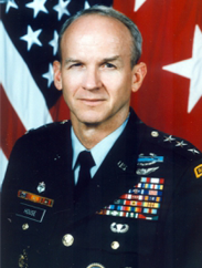 Randolph House smiling in decorated military apparel in front of an American flag.