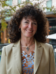 Besa Martin smiling in a tan suit and blue blouse 