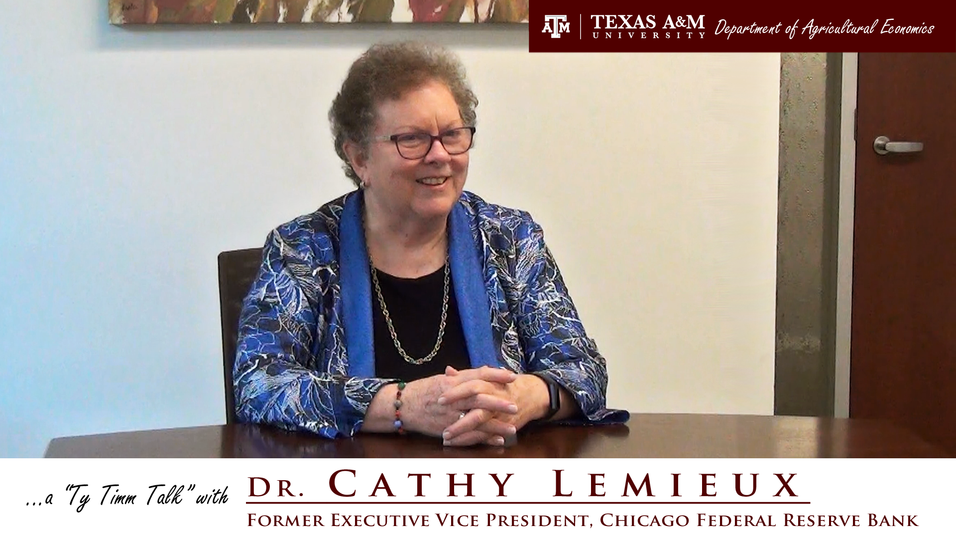 The words "a ty timm talk with Dr. Cathy Lemieux - Former Executive Vice President, Chicago Federal Reserve Bank" run along the bottom. Dr. Lemieux is seated at a table and wearing a blue floral outfit, smiling with clasped hands.