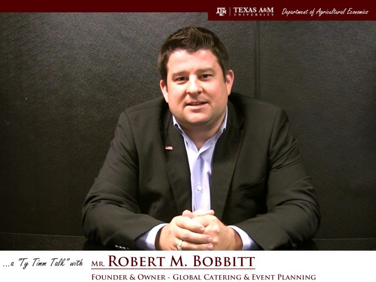 The words "a ty timm talk with Mr. Robert M. Bobbitt - founder & owner - Global catering & Event Planning" run along the bottom. Mr. Bobbitt sits with hands clasped in front of a black background, wearing a black suit.