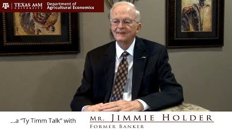 The words "a Ty Timm talk with Mr. Jimmie Holder - former banker" run along the bottom. Mr. Holder is seated at a marble table in a black suit.