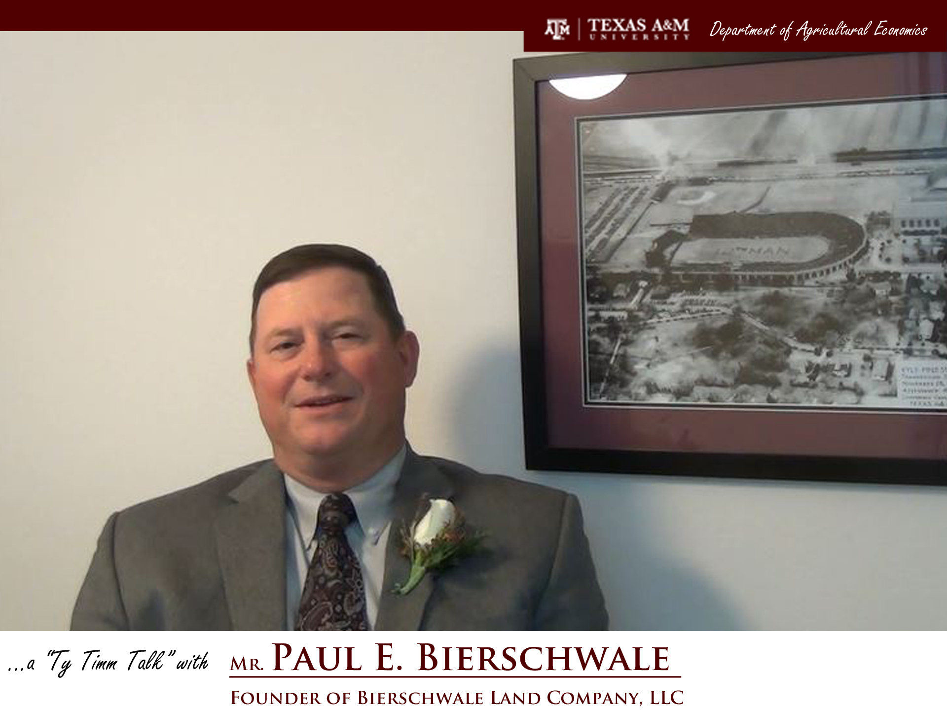 The words "a ty timm talk with Mr. Paul E. Bierschwale - founder of bierschwale land company, LTC" run along the bottom. Mr. Bierschwale is seated in front a framed black and white photo of TAMU while wearing a dark grey suit, a dark tie, and a white flower on his lapel. 